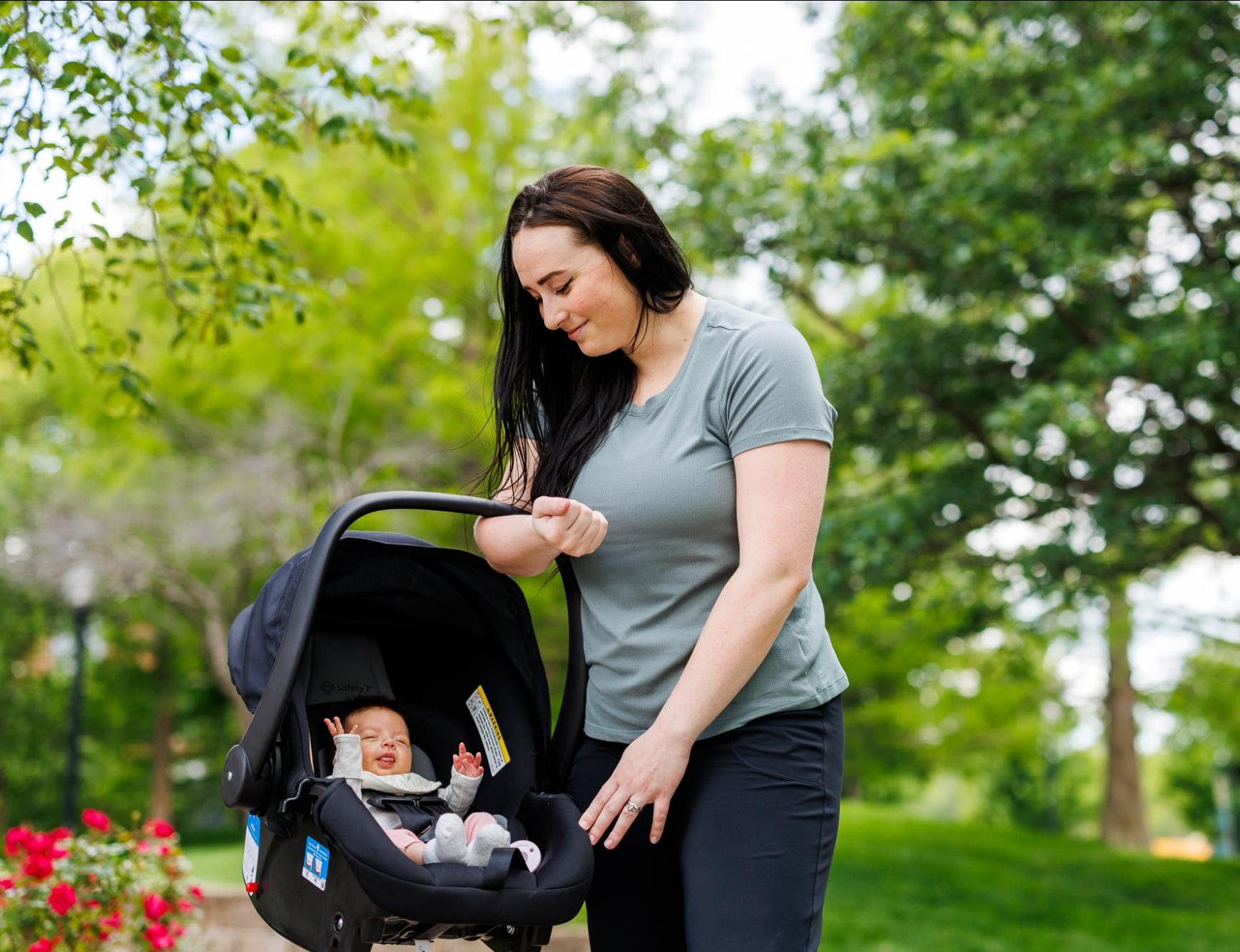 Woman Holding her Baby in a Carrier 