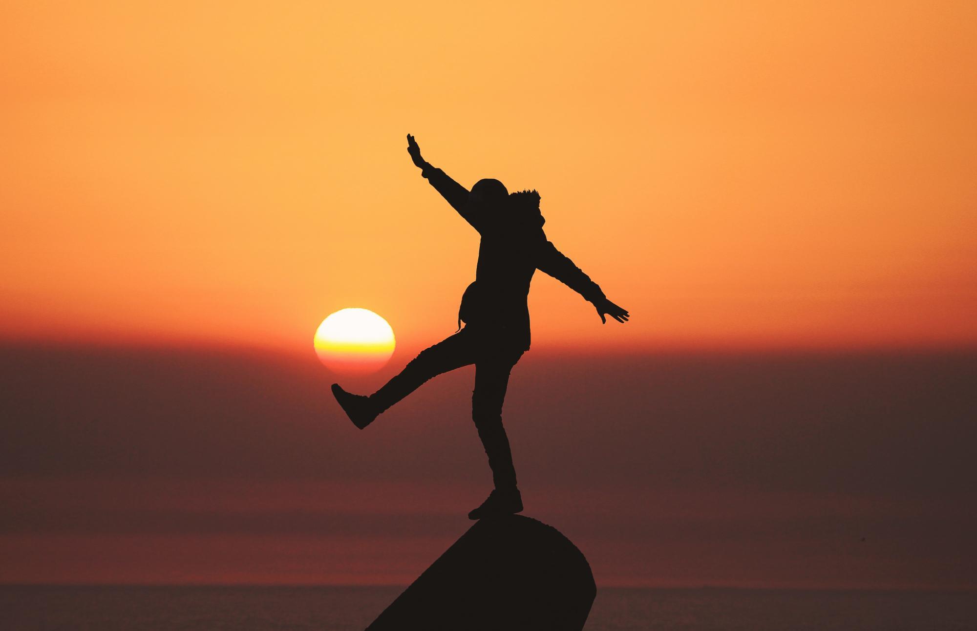 person balancing on rock
